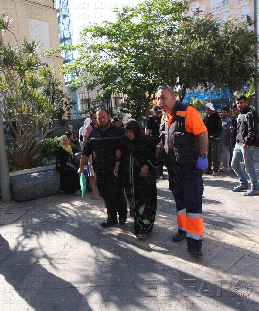 Los empleados del 061 ayudan a la mujer enferma para ir hasta la ambulancia