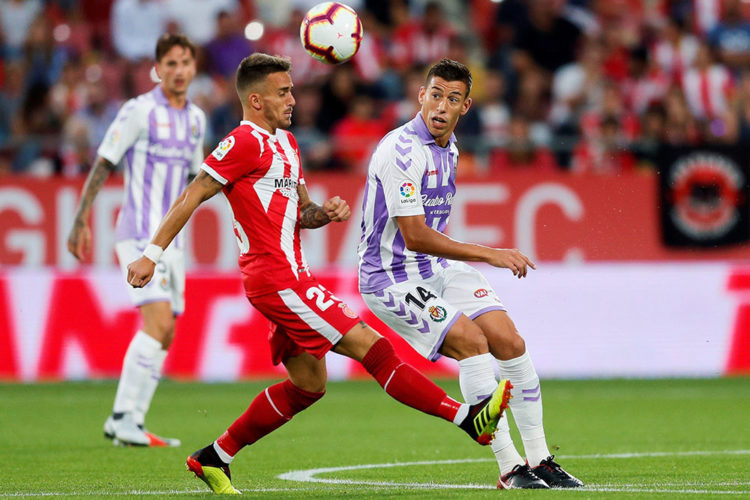 El centrocampista del Girona Aleix Garcia (i) lucha el balón con el marroquí Anuar Mohamed, del Valladolid, durante el primer partido de Liga en Primera división que se juega esta tarde en el estadio Montilivi, en Girona.