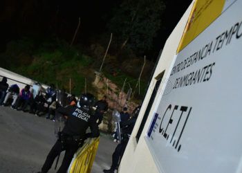 La Policía controlando en la puerta a varios subsaharianos desalojados del centro.