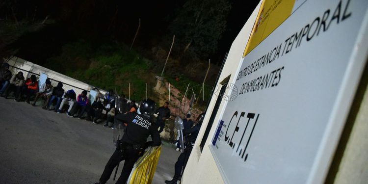 La Policía controlando en la puerta a varios subsaharianos desalojados del centro.