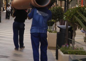 Obreros trasladando una tubería