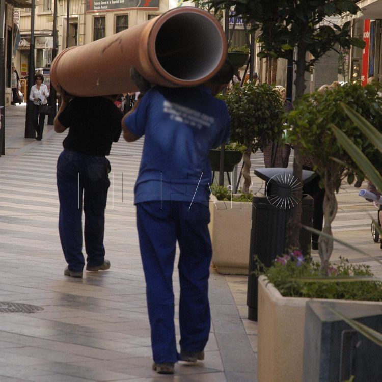 Obreros trasladando una tubería