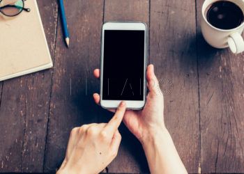 primer-plano-mano-mujer-que-sostiene-telefono-pantalla-blanco-espacio-copia-su-publicidad-mujer-mano-usando-telefono-cafeteria_1627-775