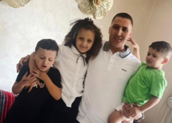 El pequeño Younes en brazos de su padre y acompañado de sus hermanos.