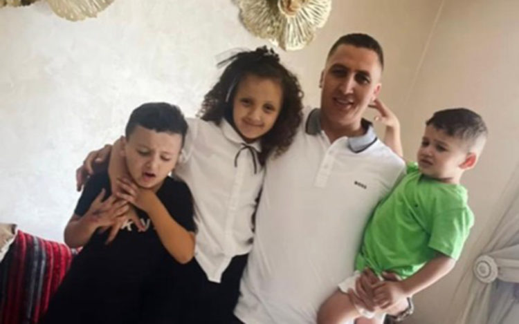 El pequeño Younes en brazos de su padre y acompañado de sus hermanos.