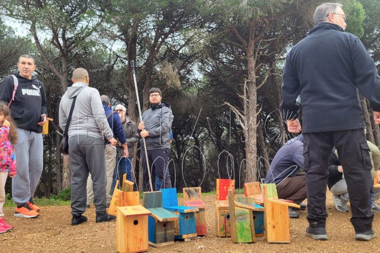 Niños y adultos disfrutan de un día de naturaleza colocando cajas nido