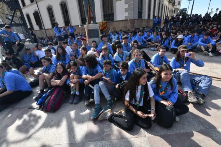grupo de jovenes scout sentados en el suelo